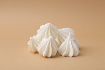 Obraz premium Delicious meringue cookies on beige background, closeup