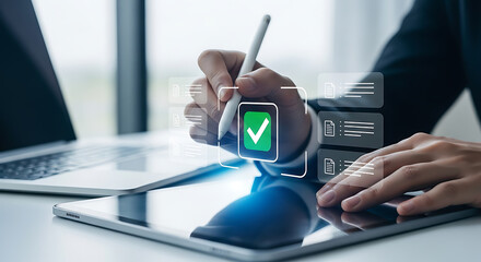 Naklejka premium Person using a stylus on a tablet with a green checkmark to approve documents online, next to a laptop computer.
