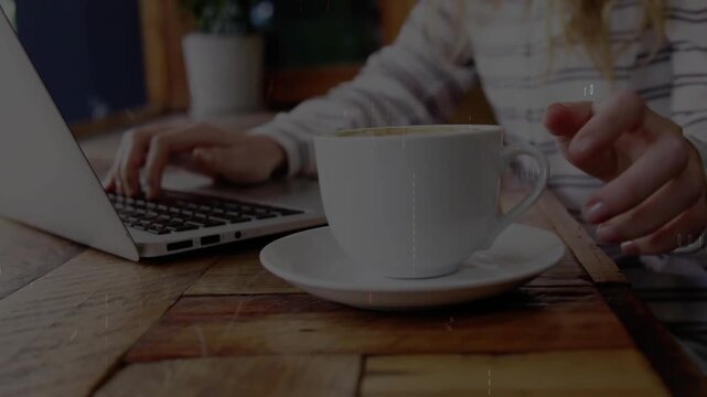 Woman tapping keyboard pausing hand reaching coffee cup for sip while binary code enveloping desk