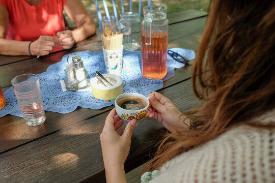 Women Talking and Drinking Turkish Coffee Outdoors