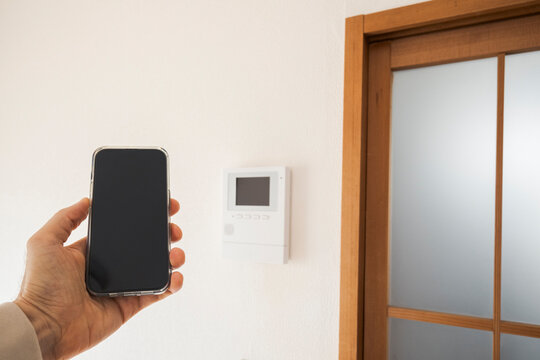 Smartphone held up near smart home controller