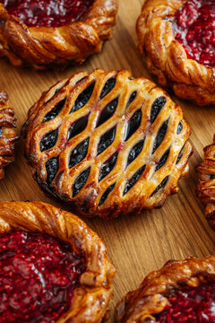 Assorted berry danishes on wooden surface