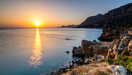 Sunrise over turquoise sea, rocky coastline