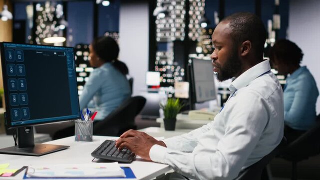 Black worker uses AI chatbot system at desktop for problem solving tasks, futuristic technology highlighting smart algorithms and machine learning. Communication and IT support. Camera B.