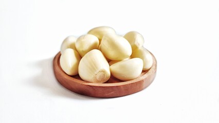 Garlic cloves and garlic bulb in a wooden plate. Isolated on white background with copy space. Clipping Path. Perfect for design element, food recipe or any commercial usage.