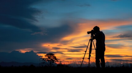 夕焼け　三脚を立て写真を撮る人物のシルエット