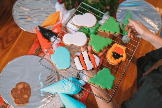 An overhead view of a board displaying Christmas gingerbread cookies baked by children during a holiday workshop. Children baking party. Preparing for New Year and Christmas.