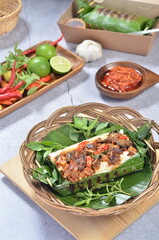 Grilled rice with fried potatoes and liver, wrapped in banana leaves, a traditional Indonesian dish