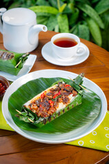 Grilled rice with fried potatoes and liver, wrapped in banana leaves, a traditional Indonesian dish