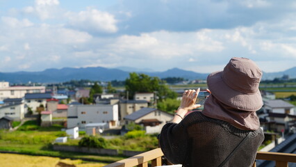 田んぼアートで写真を撮る女性