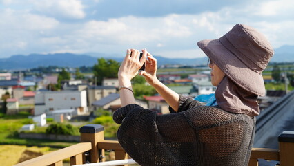 田んぼアートで写真を撮る女性