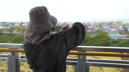 田んぼアートで写真を撮る女性