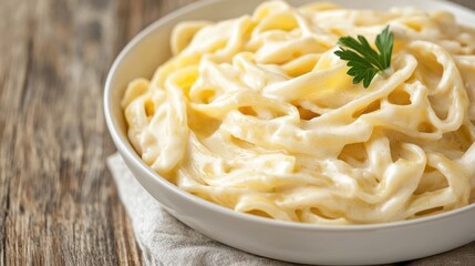 Delectable and Indulgent Alfredo Pasta Dish Served in a White Bowl Garnished with Fresh Parsley for a Savory and Comforting Italian Meal