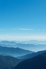 Serene view of blue mountain ranges fading into the misty distance under a clear sky, capturing natural beauty, tranquility, and peaceful atmosphere of layered mountain landscapes.