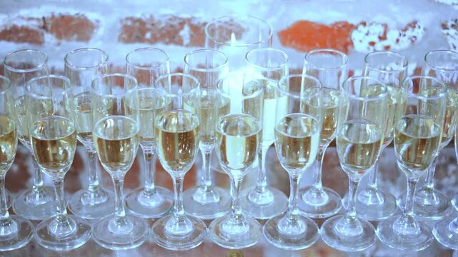 Row of champagne on table at a wedding reception ready to be served