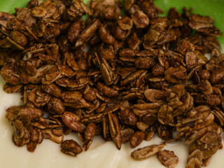 Yogurt and chocolate granola in green bowl