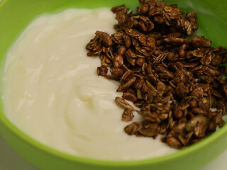 Yogurt and chocolate granola in green bowl