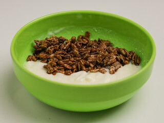 Yogurt and chocolate granola in green bowl