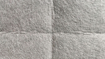Wrinkled and Textured Gray Non-Woven Fabric Close-Up with Soft Fuzz Fibers and Shadow Folds