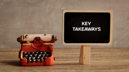 Key Takeaways Written on a Black Mini Chalkboard Next to a Vintage Red Typewriter