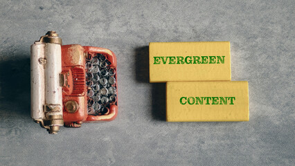 Evergreen Content Concept with Yellow Wooden Blocks and Miniature Vintage Typewriter