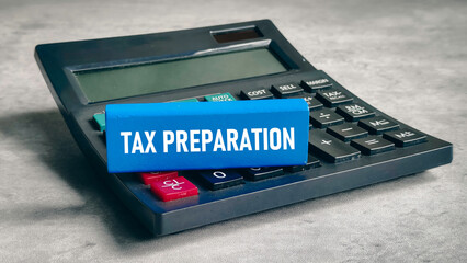 Tax Preparation Text on Blue Block Resting on Professional Calculator for Finance and Accounting