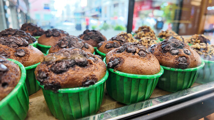 Freshly baked chocolate muffins in vibrant green cups