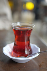 Steaming cup of turkish tea served in a glass on wooden table