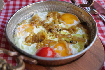 Delicious eggs cooked with onions and tomatoes in a skillet