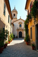 Fototapeta premium Sunlit cobblestone pathway leading to a church between aged buildings with potted plants