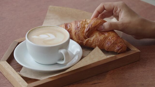 Enjoying coffee and croissant at a cozy cafe