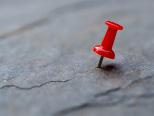 Red Pushpin on Textured Surface with Shallow Depth of Field