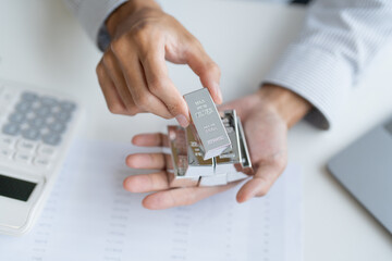 Silver bar Trading business man hand offering silver Investment financial report Trading Pure silver precious metals investment  on the stock exchange Rising prices.