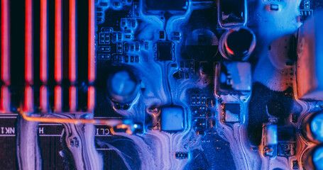 Ink drip. Mainboard chip. Defocused blue purple orange color electronic board water on abstract...