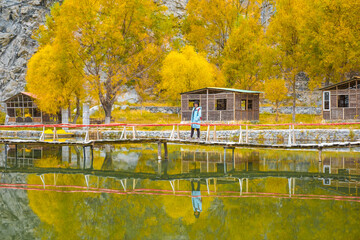 The Tourist woman on the autumn trees on Hushe valley and Gasherbrum glacier in the karakoram mountains range