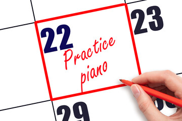 22 nd day of the month. Hand writing Practice piano reminder and drawing red frame on calendar with...