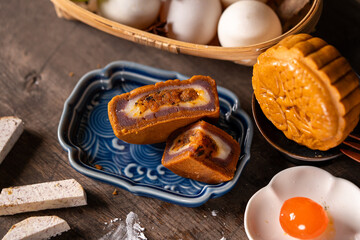 Assorted Vietnamese mooncakes with salted egg yolk and ingredients on rustic table