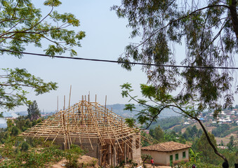 Timber roof framing for a house under construction in African village