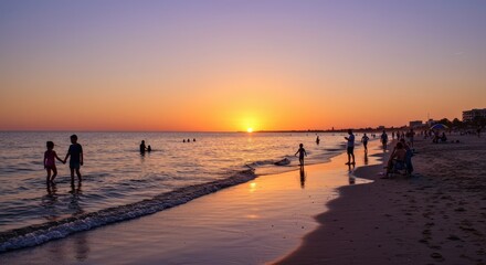 Sunset over ocean with people silhouettes on the beach