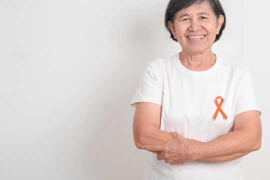 Elderly with Orange Ribbon for September Leukemia, March Kidney cancer day, Multiple Sclerosis, November Complex Regional Pain Syndrome, CRPS, COPD, Chronic Obstructive Pulmonary disease concepts
