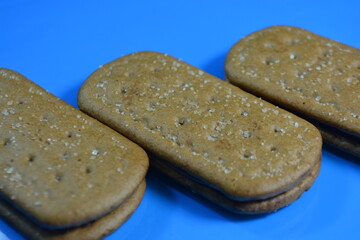 Overhead View of Rectangular Biscuits with Chocolate/Cocoa Filling on a Bright Blue Background