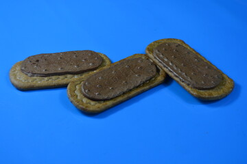 Overhead View of Rectangular Biscuits with Chocolate/Cocoa Filling on a Bright Blue Background