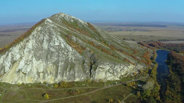 An aerial drone shot captures the majestic Shihan Yuraktau, a solitary limestone mountain and a natural monument in the Sterlitamak region of Bashkortostan, Russia. Known as heart mountain in the Bash