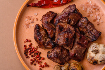 Beef, grilled meat in pieces, or kebab with sauce and vegetables. Beef in pieces