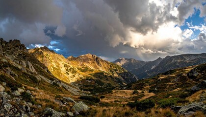 Fototapeta premium Mountain Valley Panorama with Dramatic Sky and Sunlight Illuminating Peaks
