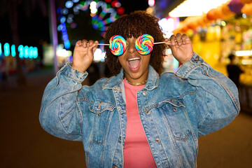 Woman enjoying carnival fun holding rainbow lollipops