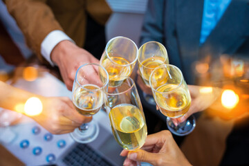 Happy group of business friends enjoying a party, celebrating with happy champagne glasses and sparkling wine, celebrating New Year at home.