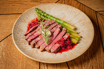 Juicy steak, fresh asparagus, and vibrant berry sauce make a perfect feast
