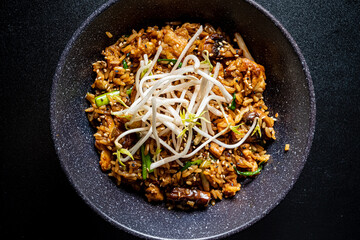 A delectable bowl of fried rice topped with fresh bean sprouts, showcasing vibrant flavors