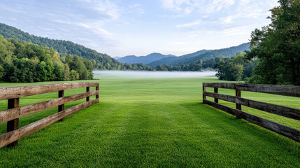 Lush green pastures and wooden fences create serene landscape with misty mountains in background